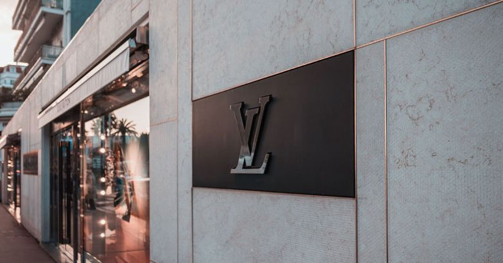 Exterior of a luxury storefront with the iconic Louis Vuitton logo sign